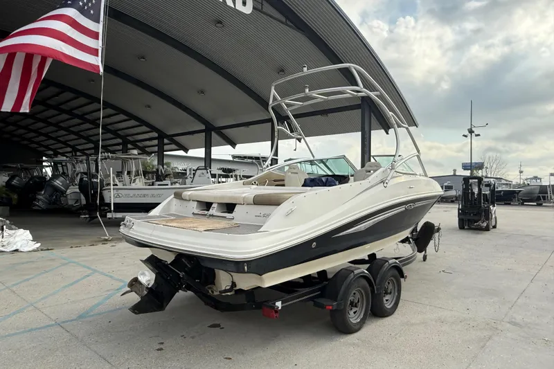 Slide: The Image of 2007 Sea Ray 210 Dual Console boat on trailer at marina, American flag visible. - 7