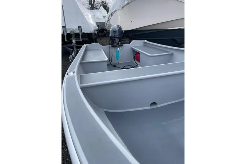 Slide: The Image of Small gray boat, Holland model 14, 2026, with motor, parked outdoors. - 3