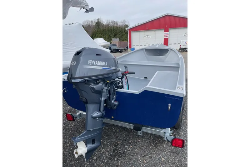 Slide: The Image of Small blue boat with Yamaha motor, Holland 14 model, 2026, parked near red building. - 6