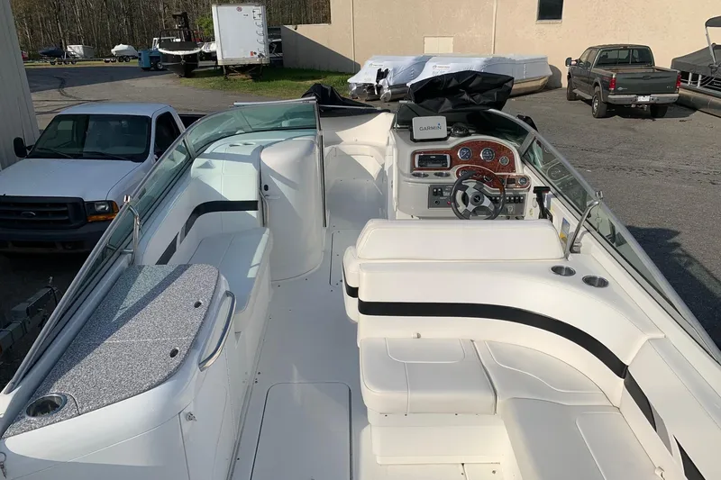 Slide: The Image of 2004 Formula 260 Bowrider boat interior with seating and dashboard, parked outdoors. - 2