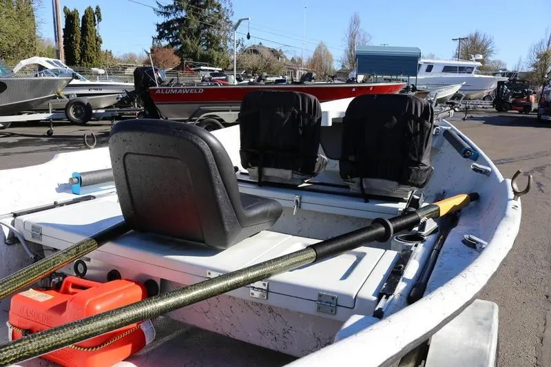 Slide: The Image of 2005 ClackaCraft 16 Drift Boat with oars and seating, parked outdoors. - 4