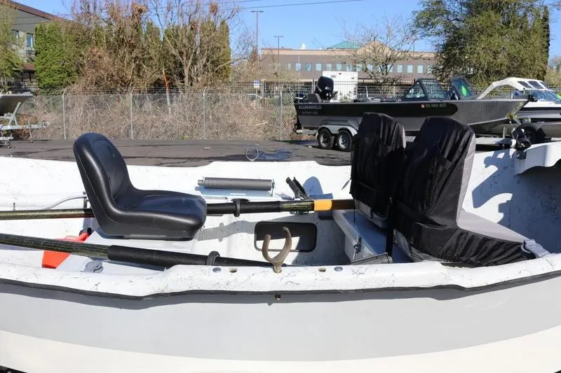 Slide: The Image of 2005 ClackaCraft 16 Drift Boat with seating and oars, parked outdoors. - 5