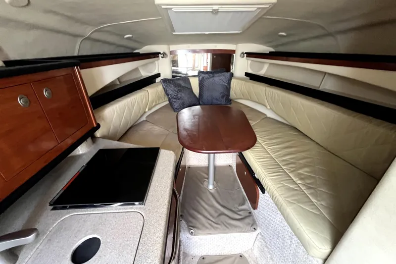 Slide: The Image of Interior of 2007 Sea Ray Sundancer 260, featuring cozy seating and a compact kitchenette. - 44