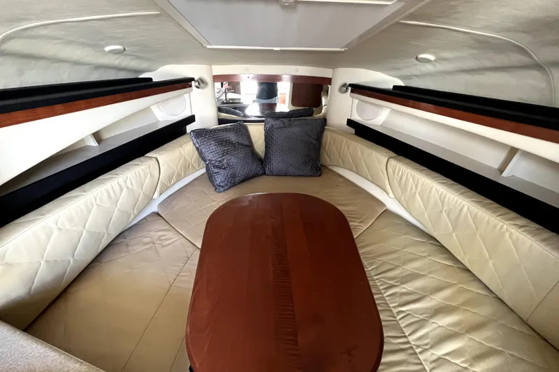 Slide: The Image of Interior cabin of 2007 Sea Ray Sundancer 260 with cushioned seating and wooden table. - 45