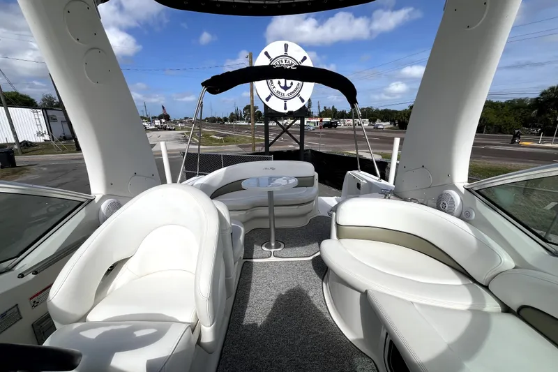 Slide: The Image of 2007 Sea Ray Sundancer 260 boat interior with white seating and table under blue sky. - 59