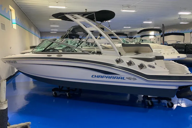 The Image of 2014 Chaparral 206 SSi boat displayed indoors on a blue floor. - 0