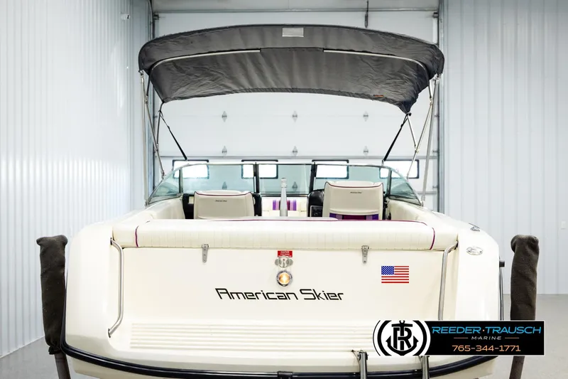 Slide: The Image of 1993 American Skier Eagle boat with canopy in a garage, featuring rear view and branding. - 6
