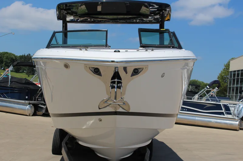 Slide: The Image of 2025 Cobalt R33 Surf boat front view, displayed outdoors on a sunny day. - 2