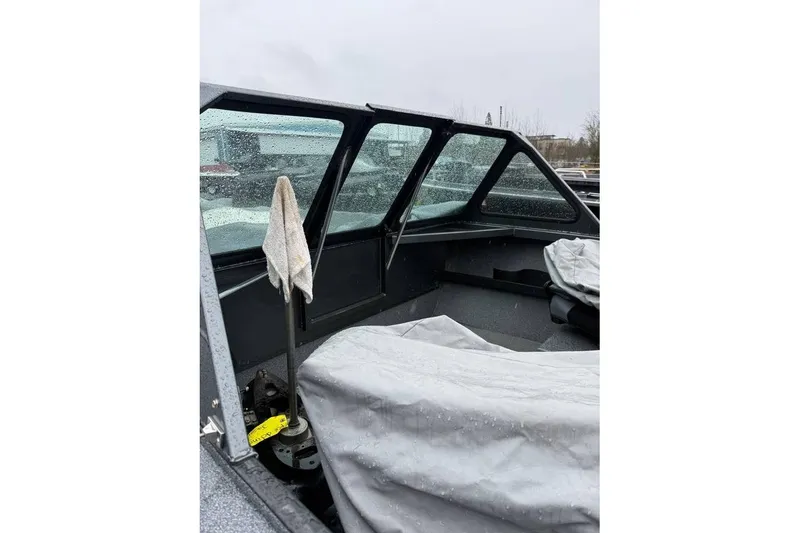 Slide: The Image of 2012 Alumaweld Super Vee Pro 23 boat interior with rain-soaked windows and covered seating. - 11