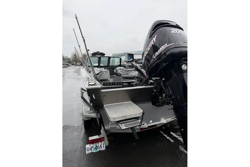 Slide: The Image of 2012 Alumaweld Super Vee Pro 23 boat with Mercury OptiMax engine, parked on wet pavement. - 12