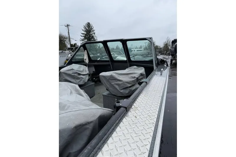 Slide: The Image of 2012 Alumaweld Super Vee Pro 23 boat interior with covered seats on a rainy day. - 9