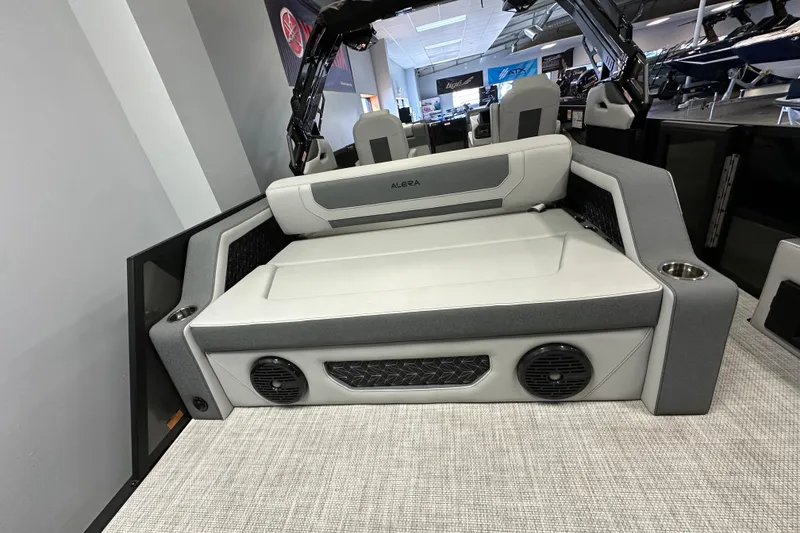 Slide: The Image of 2026 Alera M25L boat interior with cushioned seating and integrated speakers. - 16