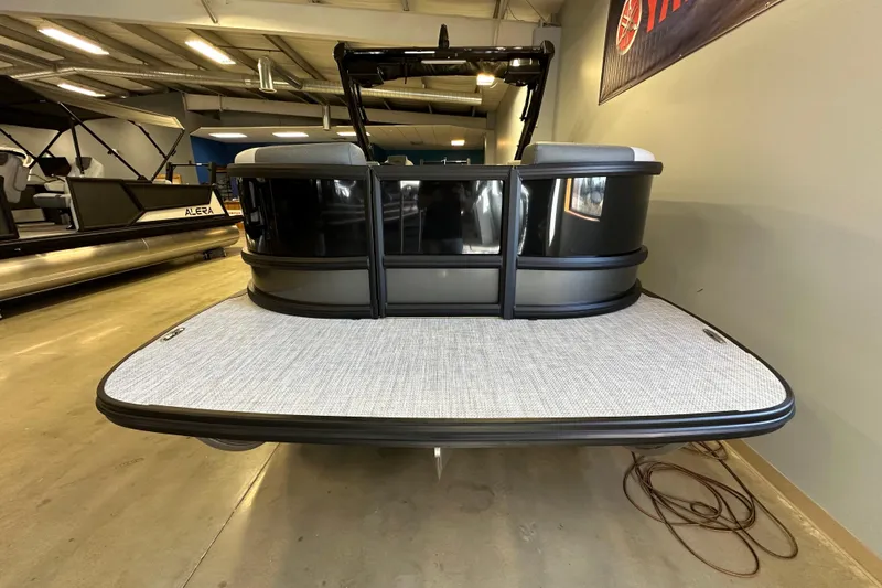 Slide: The Image of 2026 Alera M25L pontoon boat in showroom, rear view with sleek design. - 4