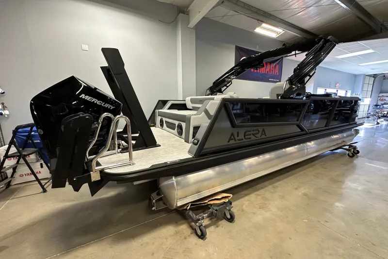 Slide: The Image of 2026 Alera M25L pontoon boat with Mercury engine in showroom setting. - 5