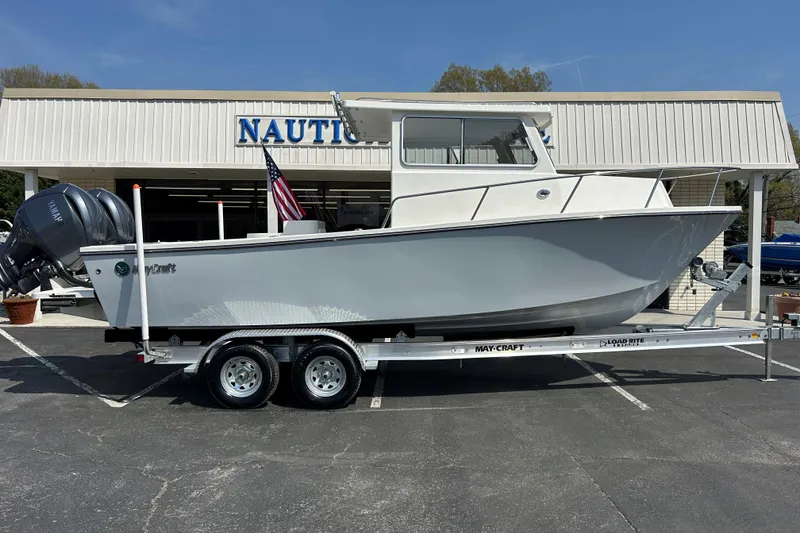 The Image of 2026 May-Craft 245 Pilot House boat on trailer outside dealership. - 1