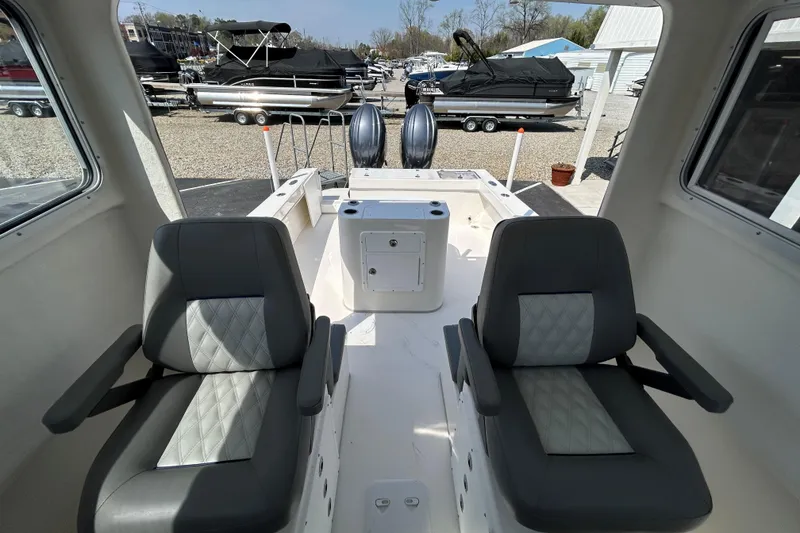 Slide: The Image of Interior of 2026 May-Craft 245 Pilot House boat with two cushioned seats. - 14