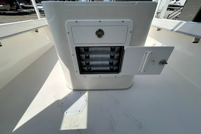 Slide: The Image of 2026 May-Craft 245 Pilot House boat storage compartment with open door and trays. - 18