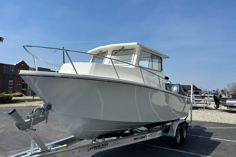 Slide: The Image of 2026 May-Craft 245 Pilot House boat on trailer under clear blue sky. - 4