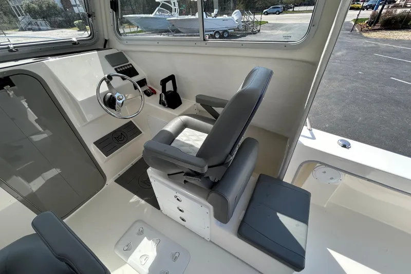 Slide: The Image of Interior of 2026 May-Craft 245 Pilot House with steering wheel and seating. - 9