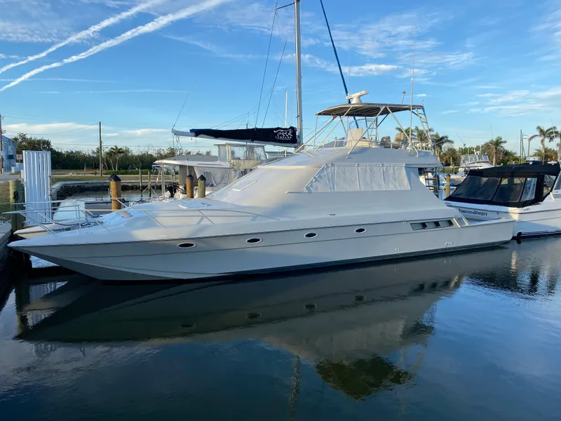 Slide: The Image of 1995 Mares 58 Power Cat yacht docked in a marina under a clear blue sky. - 27