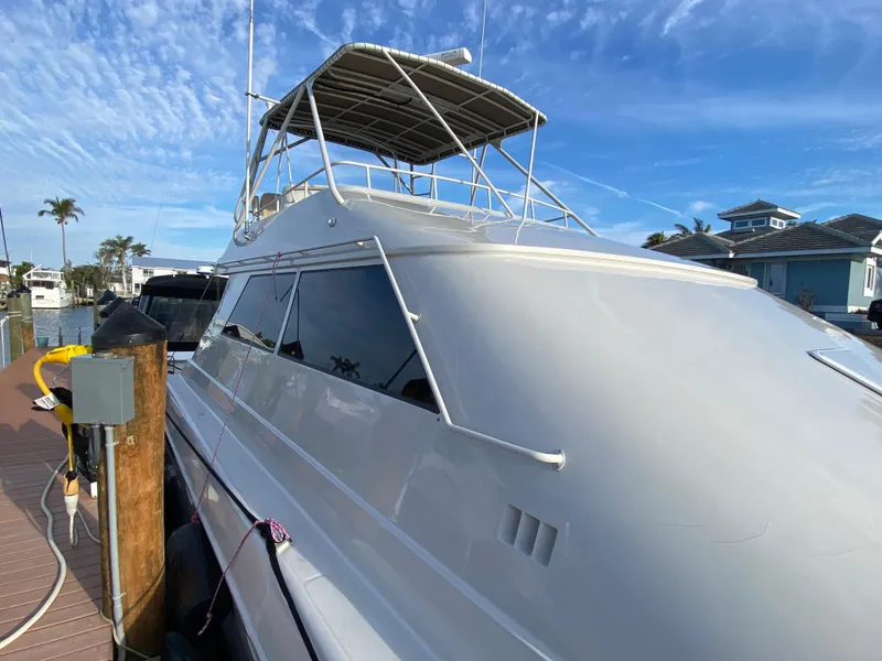 Slide: The Image of 1995 Mares 58 Power Catamaran docked under a clear blue sky. - 3