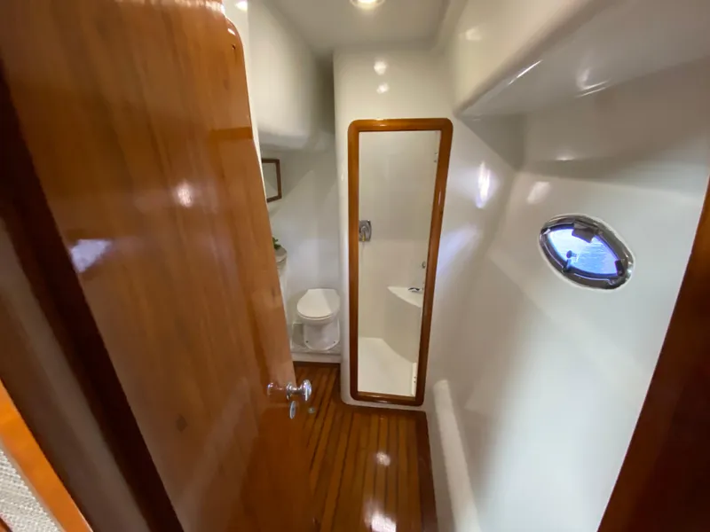 Slide: The Image of Bathroom interior of 1995 Mares 58 Power Cat with wooden door and porthole window. - 49