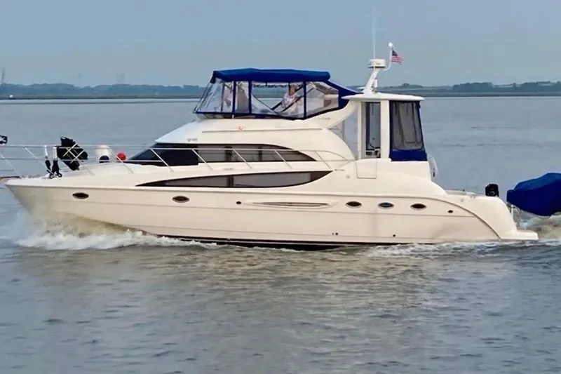 The Image of 2004 Meridian 459 Motoryacht cruising on calm waters with blue canopy. - 0