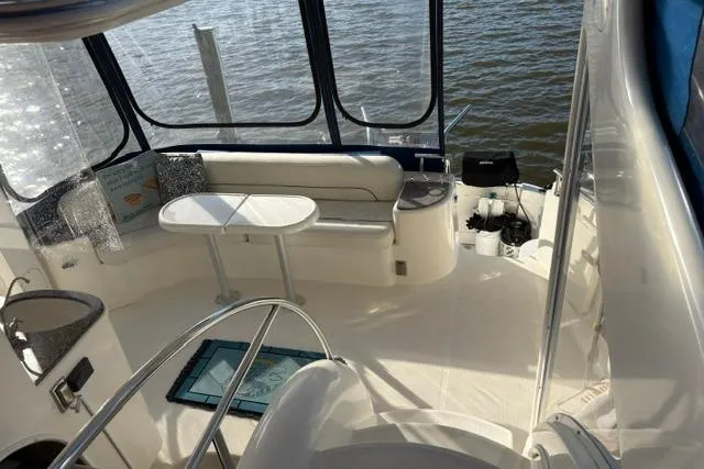 Slide: The Image of 2004 Meridian 459 Motoryacht interior with seating and table, overlooking water. - 10