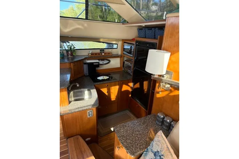 Slide: The Image of Luxurious 2004 Meridian 459 Motoryacht interior kitchen with modern amenities and elegant wood finish. - 17