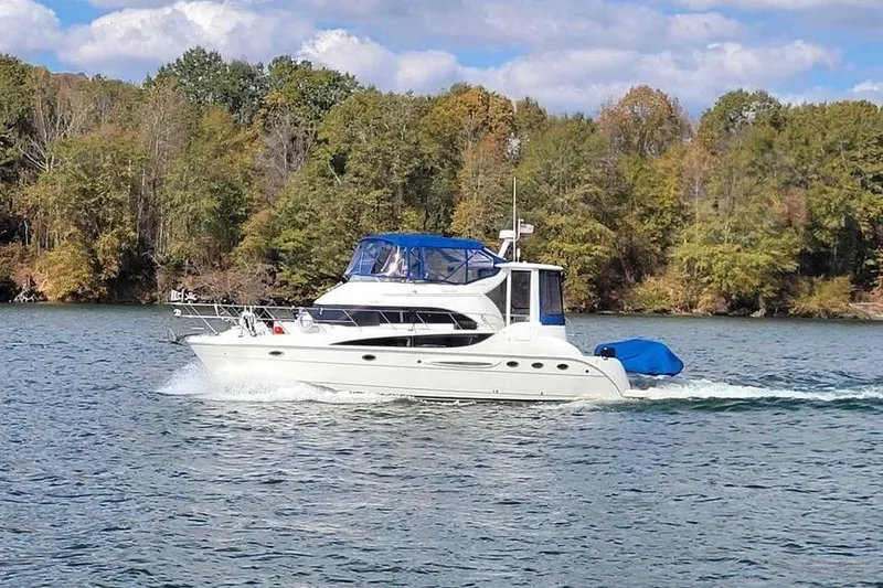 Slide: The Image of 2004 Meridian 459 Motoryacht cruising on a scenic lake with forested shoreline. - 3