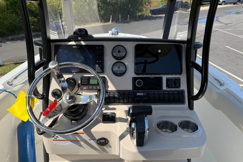 Slide: The Image of Boston Whaler 230 Outrage 2022 boat dashboard with steering wheel and controls. - 3