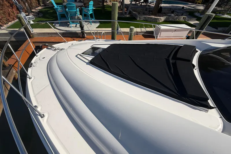 Slide: The Image of 2002 Sea Ray 480 Motor Yacht docked, featuring sleek white deck and black cover. - 11