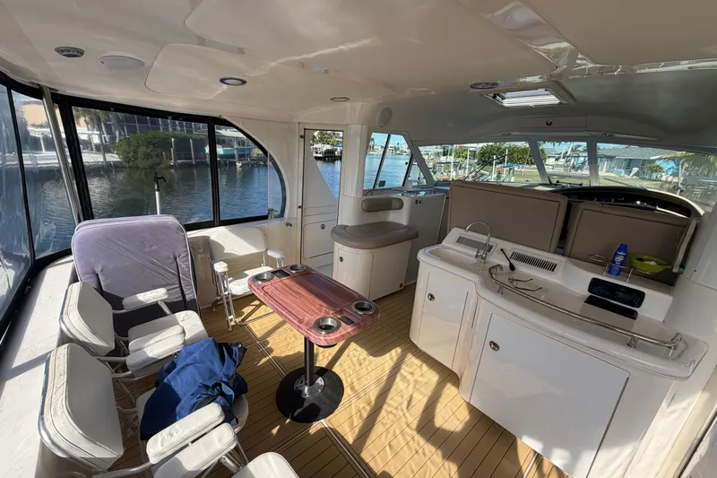 Slide: The Image of Interior of 2002 Sea Ray 480 Motor Yacht with seating and kitchenette, docked by water. - 13
