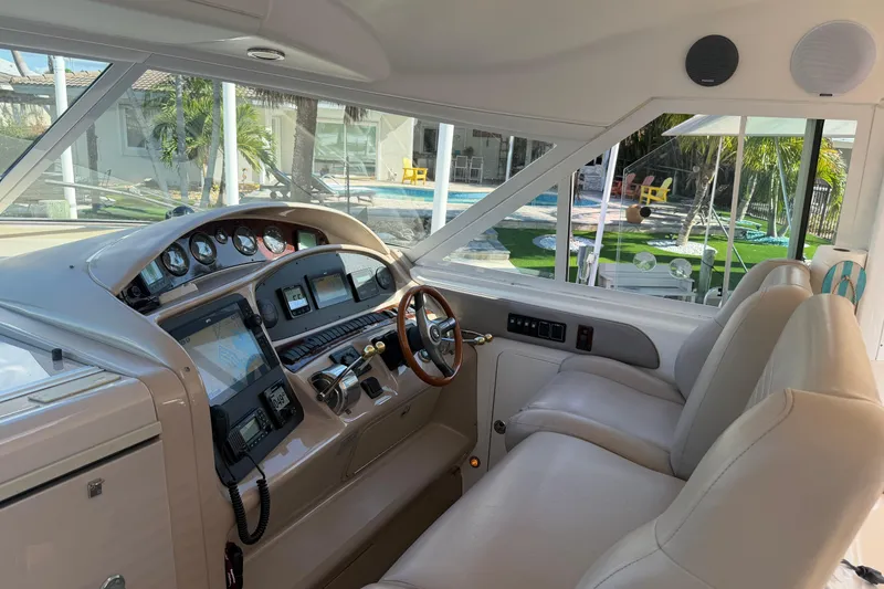 Slide: The Image of 2002 Sea Ray 480 Motor Yacht helm with modern controls and luxurious seating. - 14