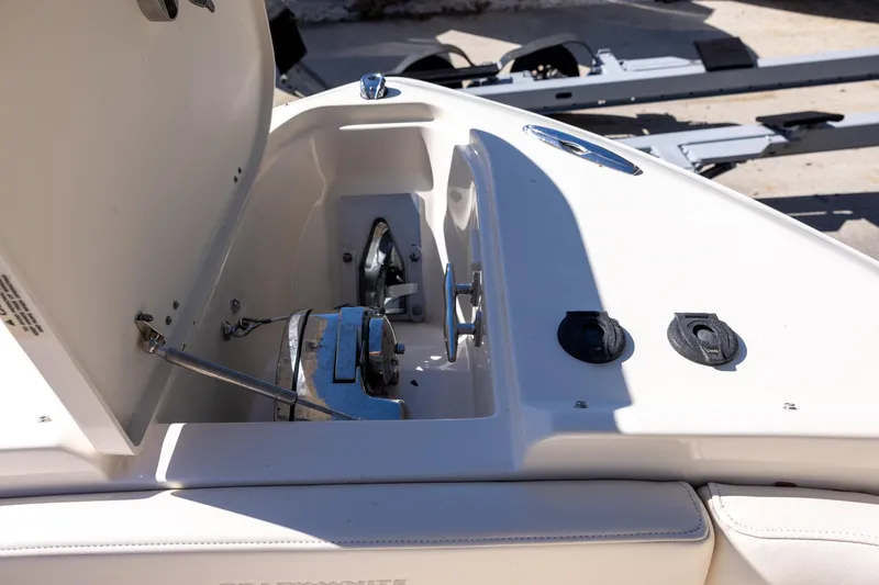 Slide: The Image of 2022 Grady-White Freedom 275 boat anchor compartment with open hatch and controls. - 18