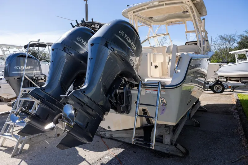 Slide: The Image of 2022 Grady-White Freedom 275 boat with dual Yamaha 200 engines, docked with ladder access. - 2