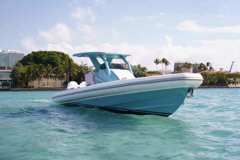 Slide: The Image of Novielli Veloche 2025 boat cruising on clear turquoise water near a tropical shoreline. - 20