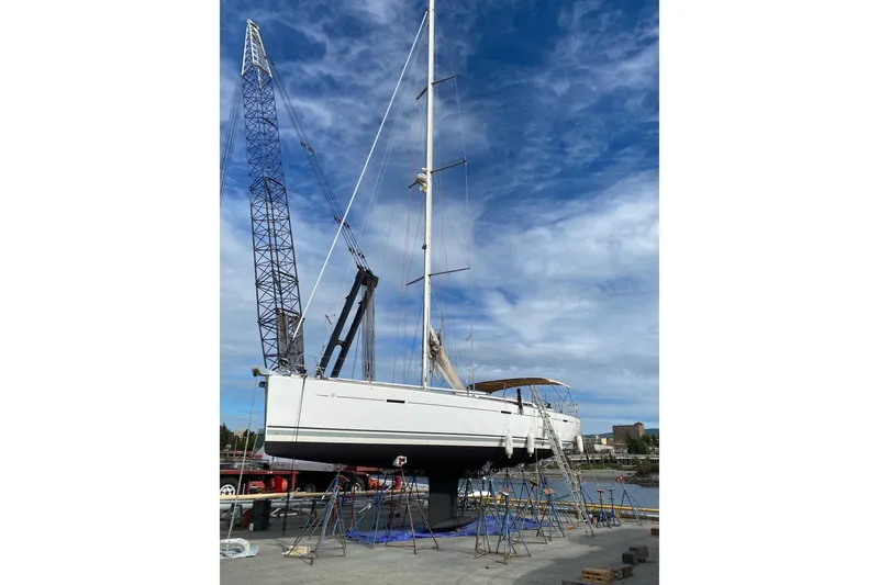 Slide: The Image of 2011 Dufour 525 Grand Large sailboat on dry dock with crane and blue sky. - 19
