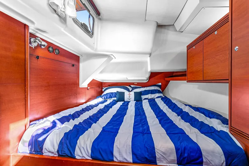 Slide: The Image of Cozy cabin interior of 2011 Dufour 525 Grand Large with striped bedding and wooden cabinetry. - 39