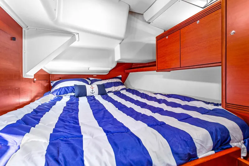 Slide: The Image of Cozy cabin interior of 2011 Dufour 525 Grand Large with striped bedding and wooden cabinets. - 40