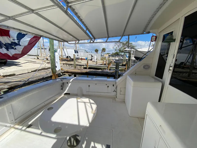 Slide: The Image of 1982 Bertram 46.6 War Wagon boat interior with canopy, docked at marina. - 14