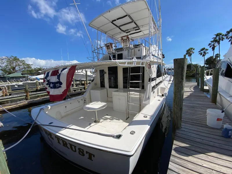 Slide: The Image of 1982 Bertram 46.6 War Wagon yacht docked at marina under clear blue sky. - 2
