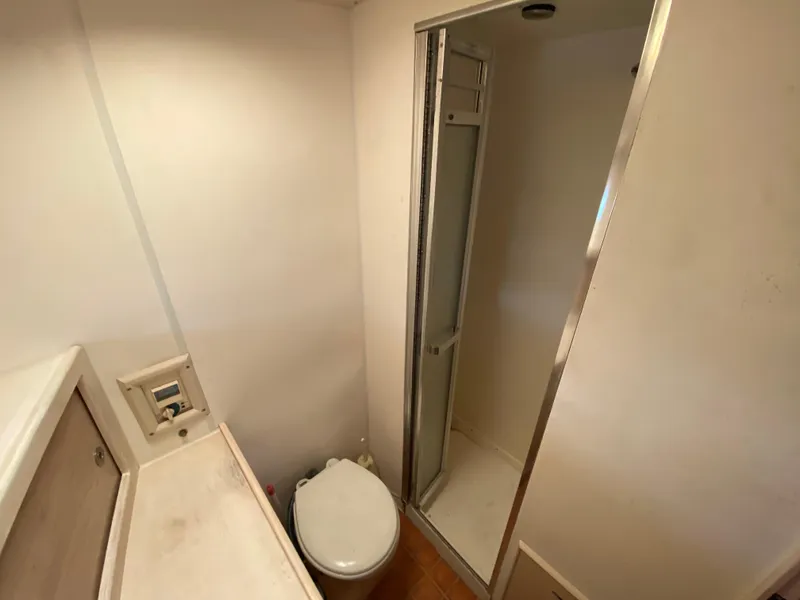 Slide: The Image of Bathroom interior of 1982 Bertram 46.6 War Wagon yacht, featuring shower and toilet. - 29