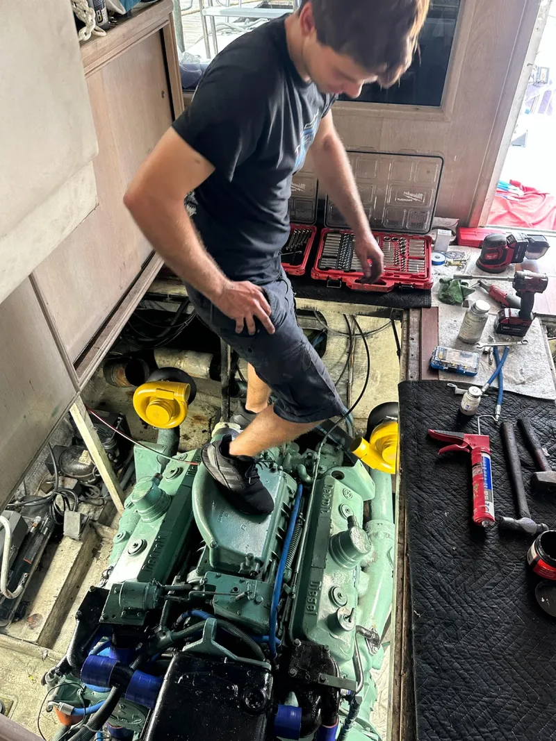 Slide: The Image of Man working on engine of 1982 Bertram 46.6 War Wagon boat. - 42
