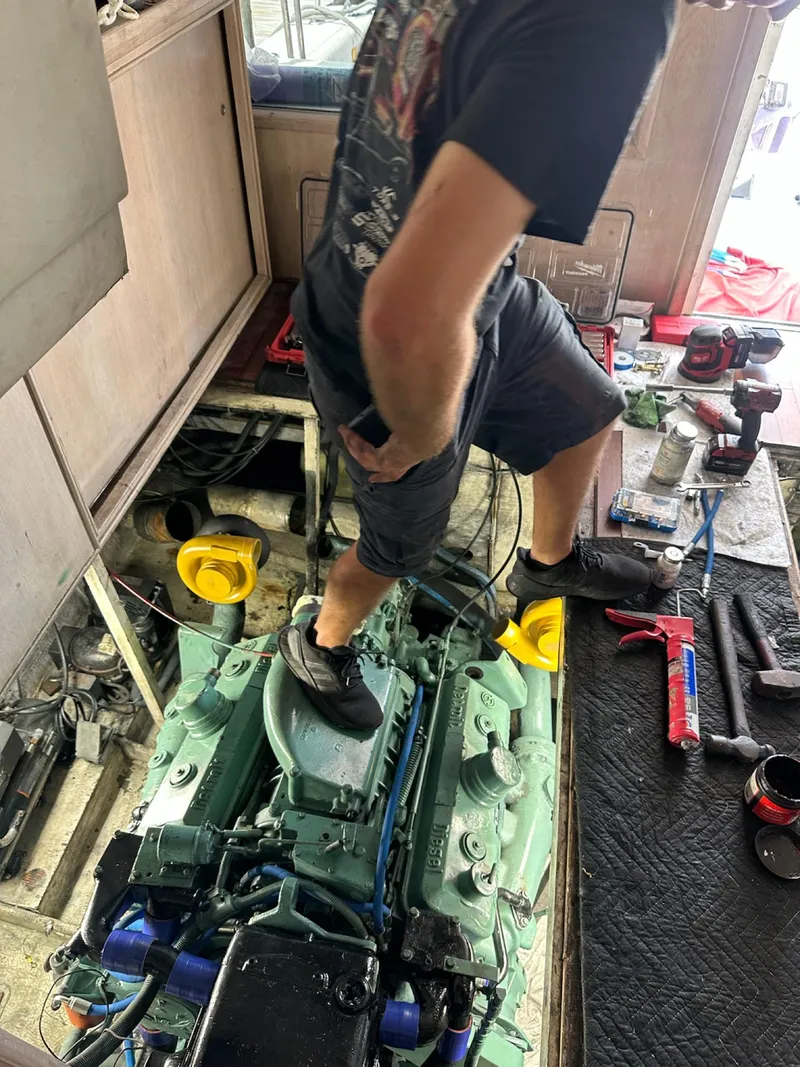 Slide: The Image of Man working on engine of 1982 Bertram 46.6 War Wagon boat. - 45