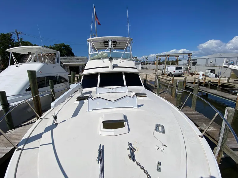 Slide: The Image of 1982 Bertram 46.6 War Wagon yacht docked at marina under clear blue sky. - 8