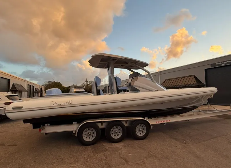Slide: The Image of 2026 Novielli Veloche 349 boat on trailer at sunset, parked near industrial buildings. - 7