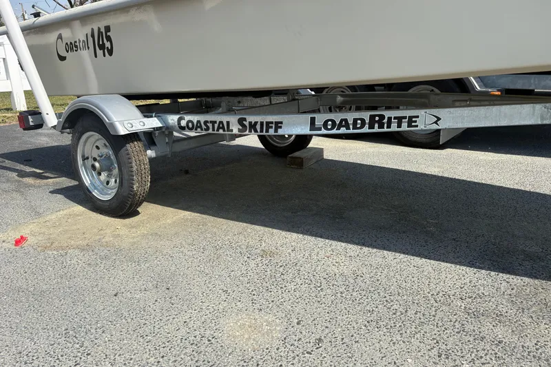 Slide: The Image of Trailer for 2025 Coastal Skiff 145 boat on pavement. - 3