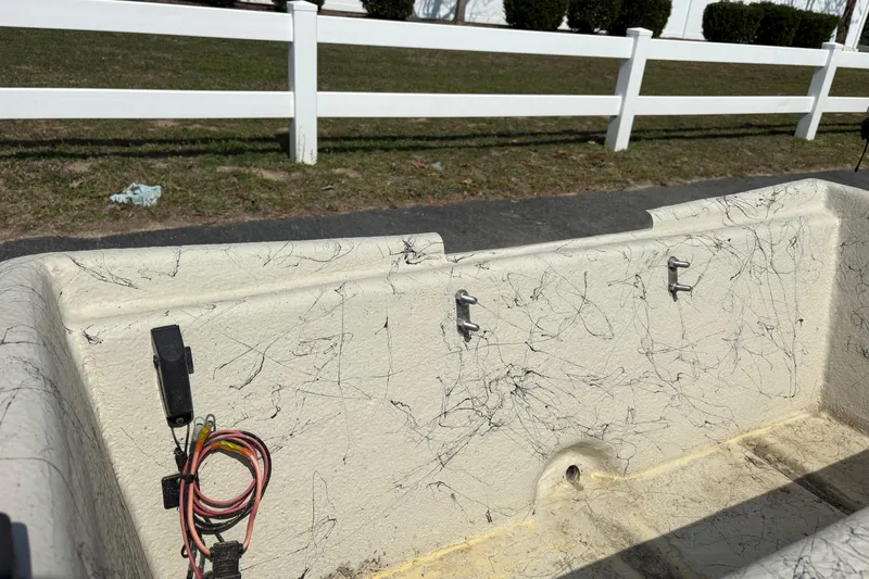 Slide: The Image of Interior of a 2025 Coastal Skiff 145 boat with wiring and hooks visible. - 5