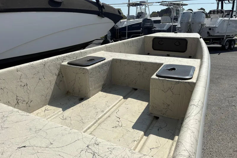 Slide: The Image of 2025 Coastal Skiff 145 boat interior with textured seating and storage compartments. - 6